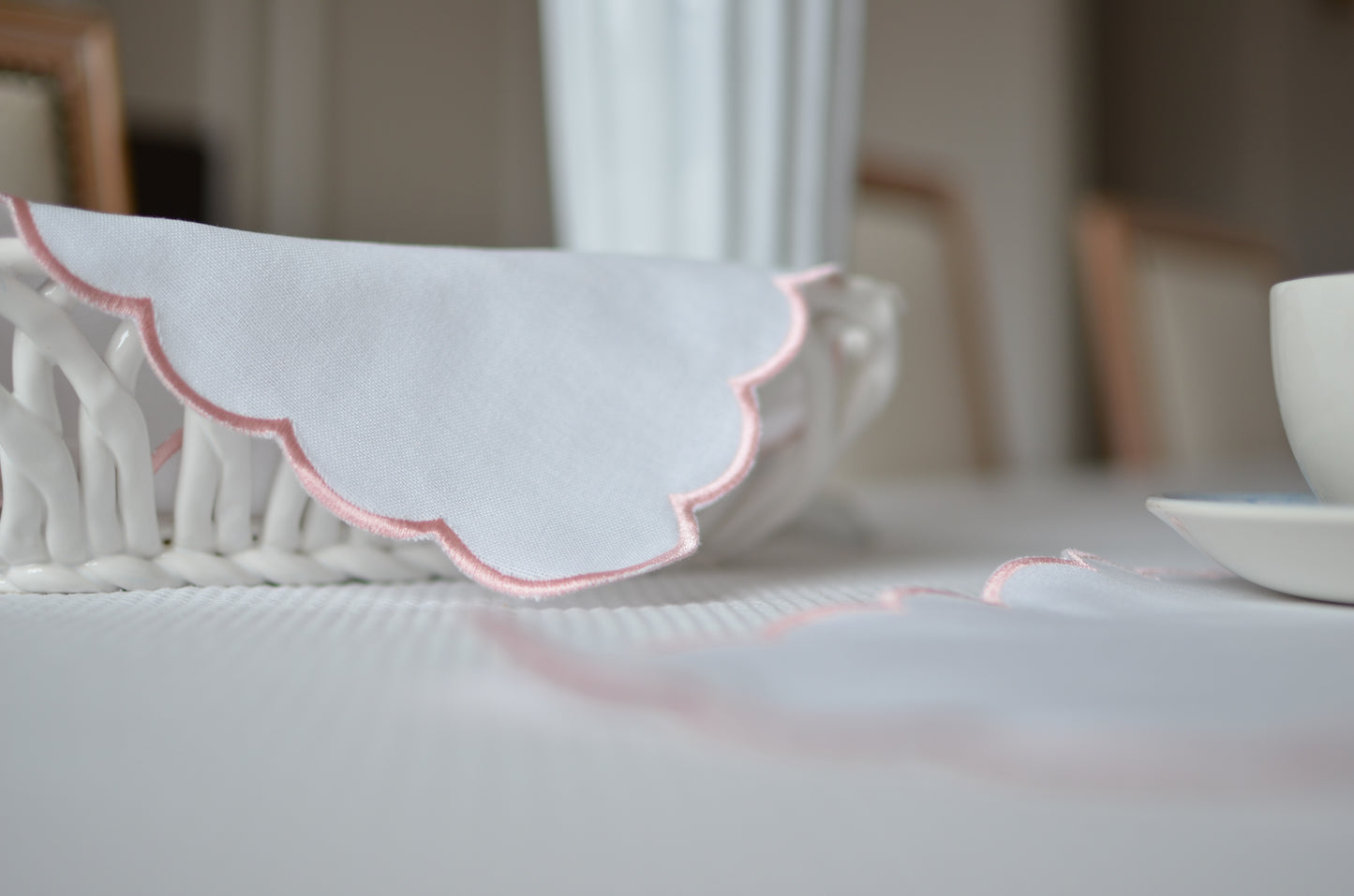 White cotton napkin with a pink scalloped edge