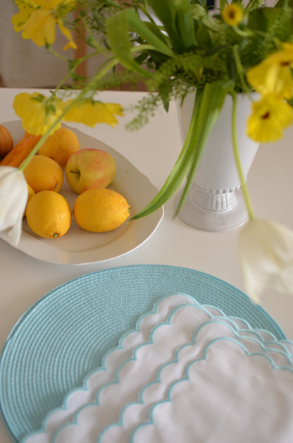 White cotton napkin with a turquoise scalloped edge