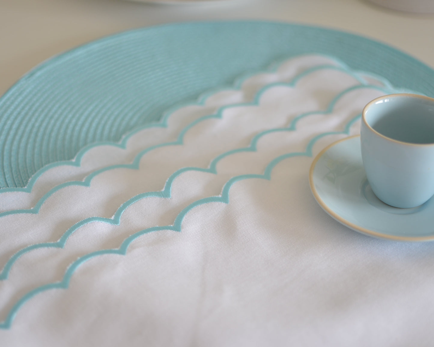 White cotton napkin with a turquoise scalloped edge