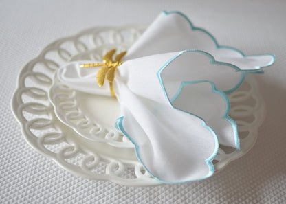 White cotton napkin with a turquoise scalloped edge
