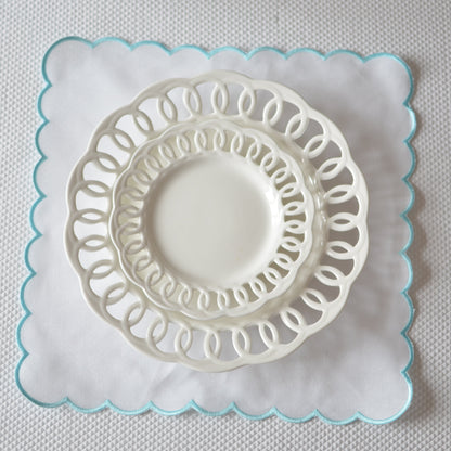White cotton napkin with a turquoise scalloped edge