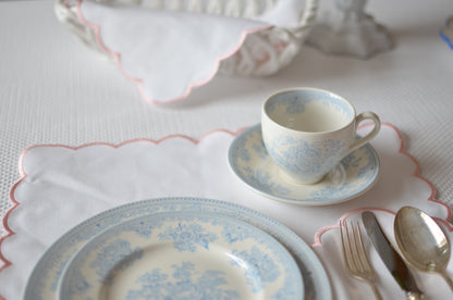 White cotton napkin with a pink scalloped edge