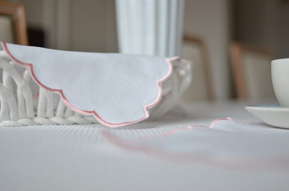 White cotton napkin with a pink scalloped edge