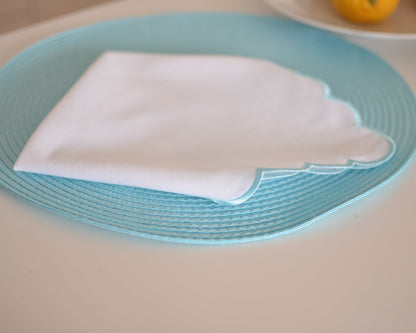 White cotton napkin with a turquoise scalloped edge
