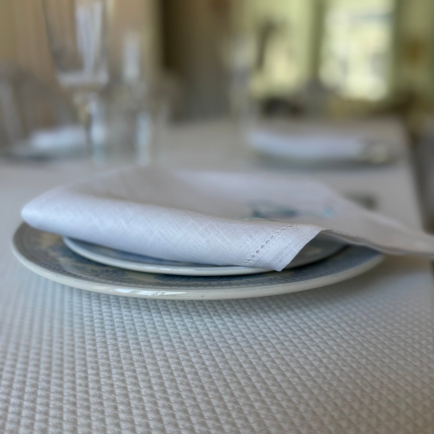 White linen napkin with a monogrammed blue bow