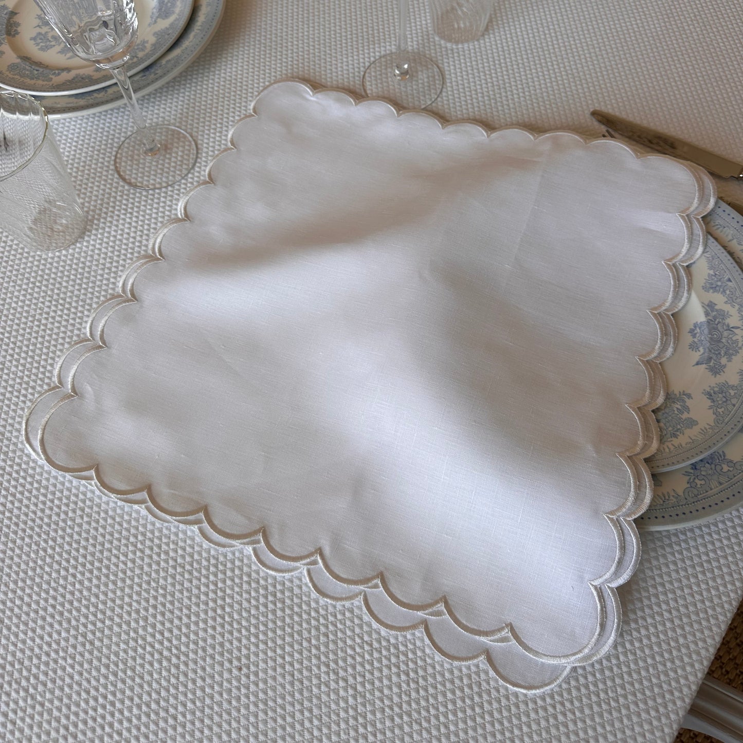 White linen napkin with a white scalloped edge