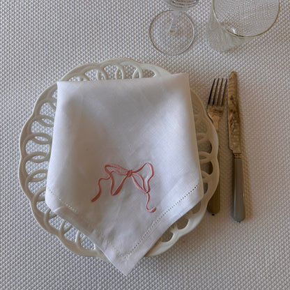 White linen napkin with a monogrammed pink bow