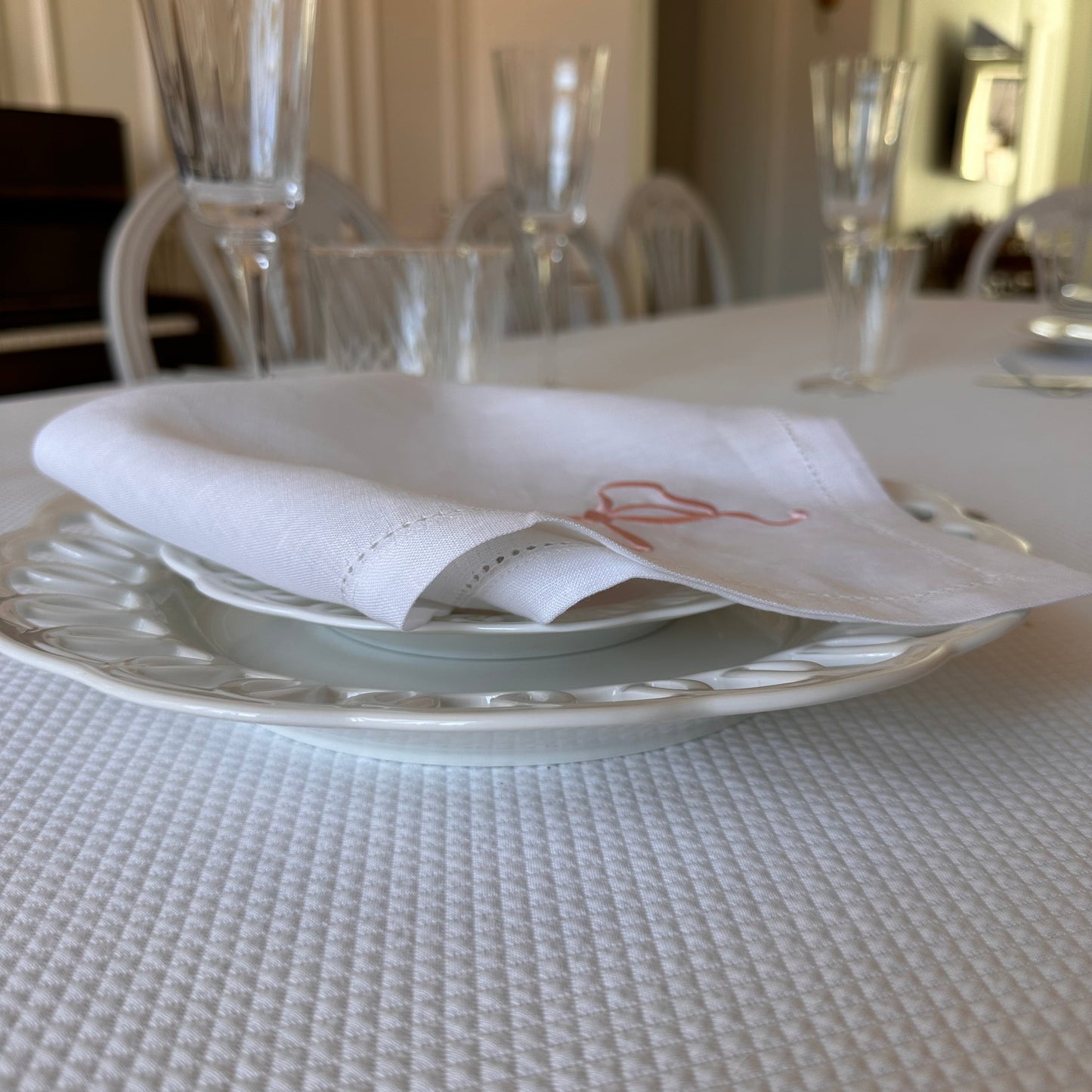 White linen napkin with a monogrammed pink bow
