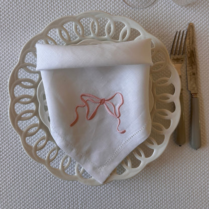 White linen napkin with a monogrammed pink bow