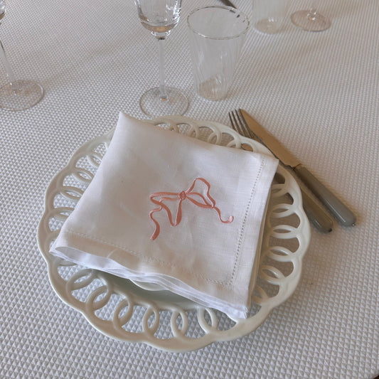 White linen napkin with a monogrammed pink bow