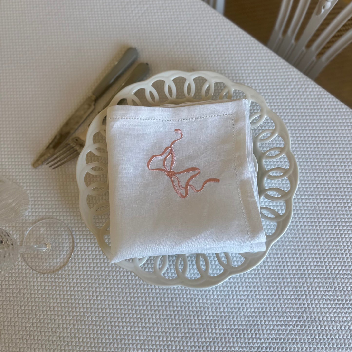 White linen napkin with a monogrammed pink bow