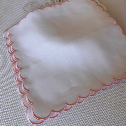 White linen napkin with a pink scalloped edge