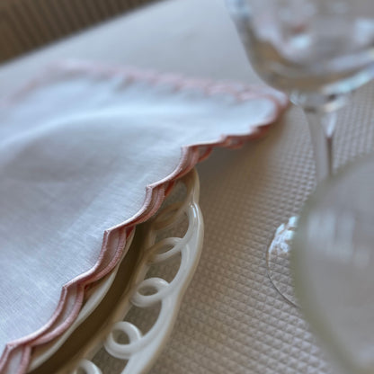 White linen napkin with a pink scalloped edge