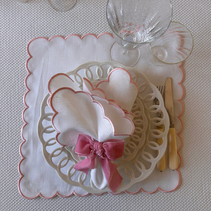 White linen napkin with a pink scalloped edge