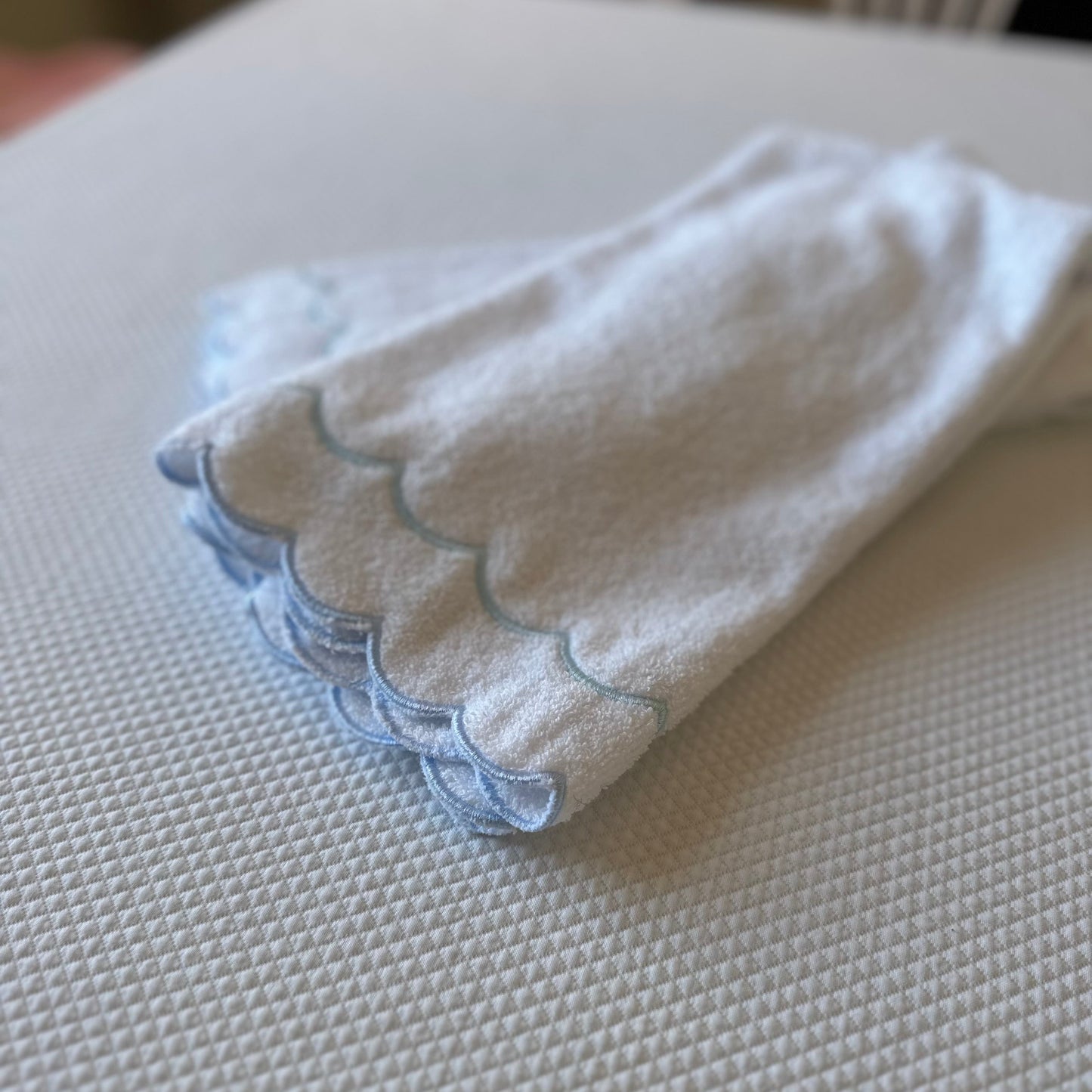 A scalloped edge hand towel set of two